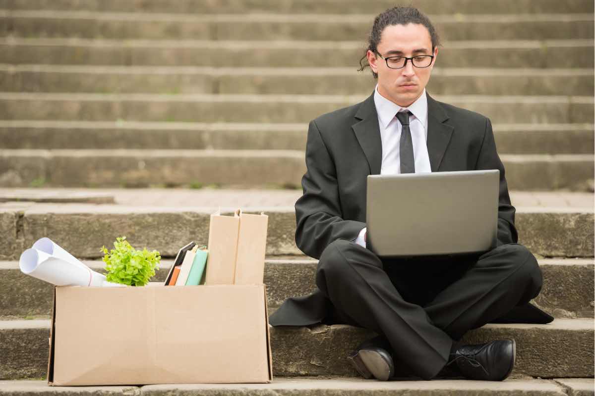 Un disoccupato cerca lavoro seduto su una scalinata