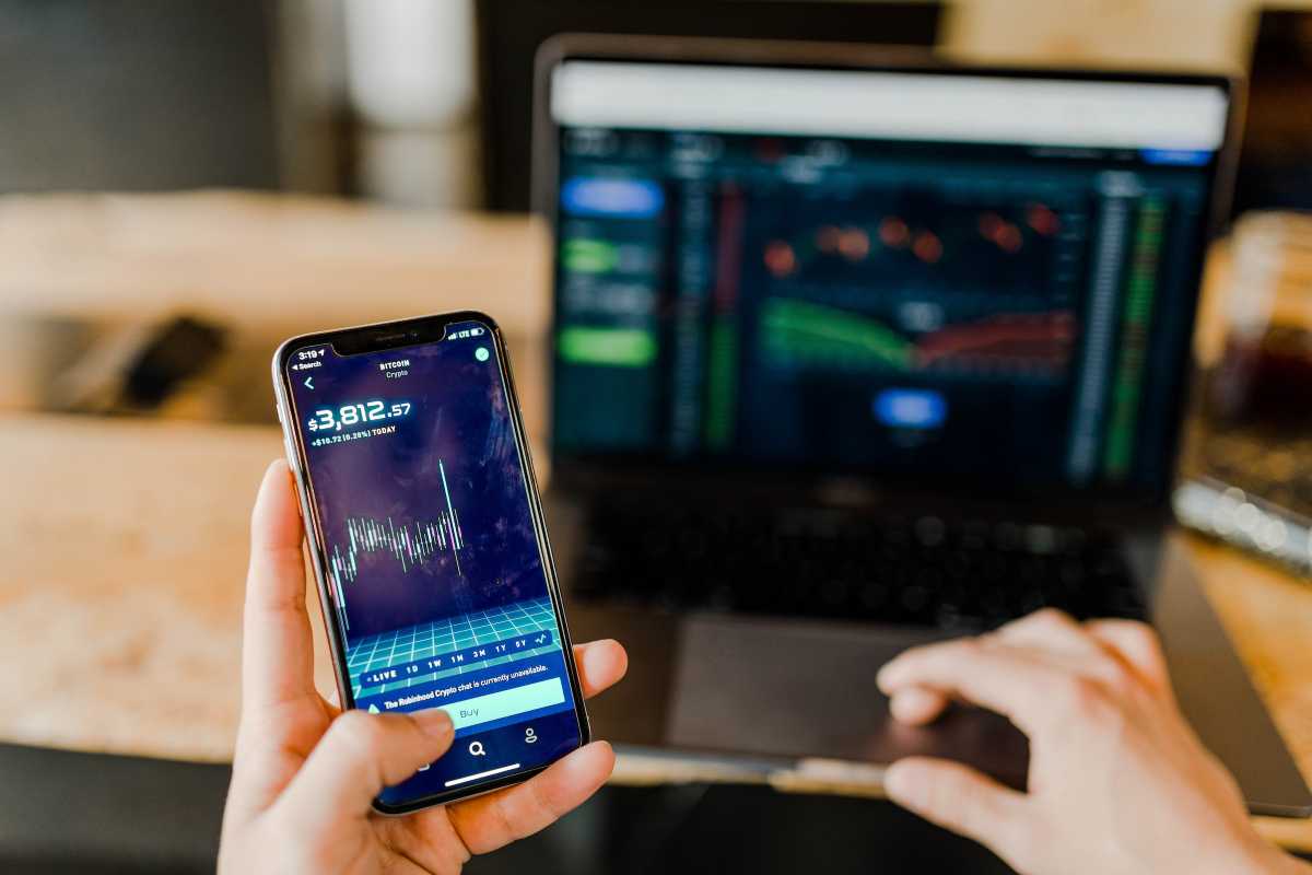 Ragazzo usa pc e smartphone per curare i propri fondi Exchange Traded Funds