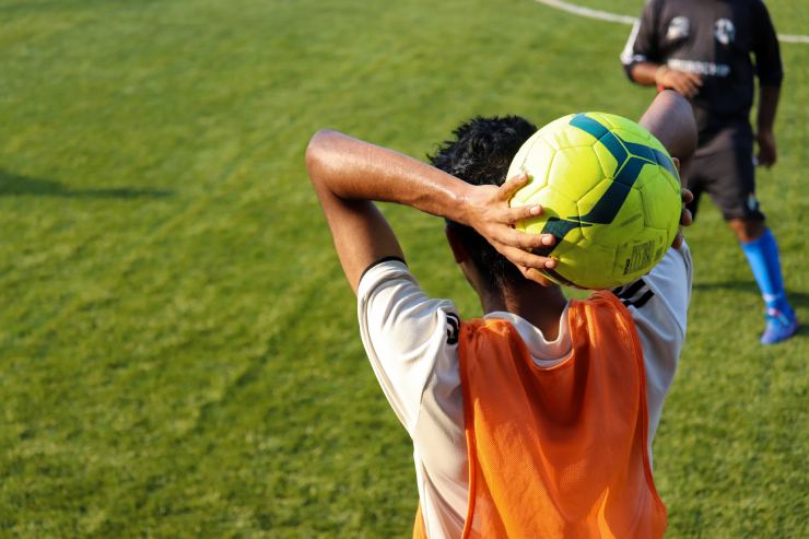 Giocatore di calcio impegnato in una rimessa laterale