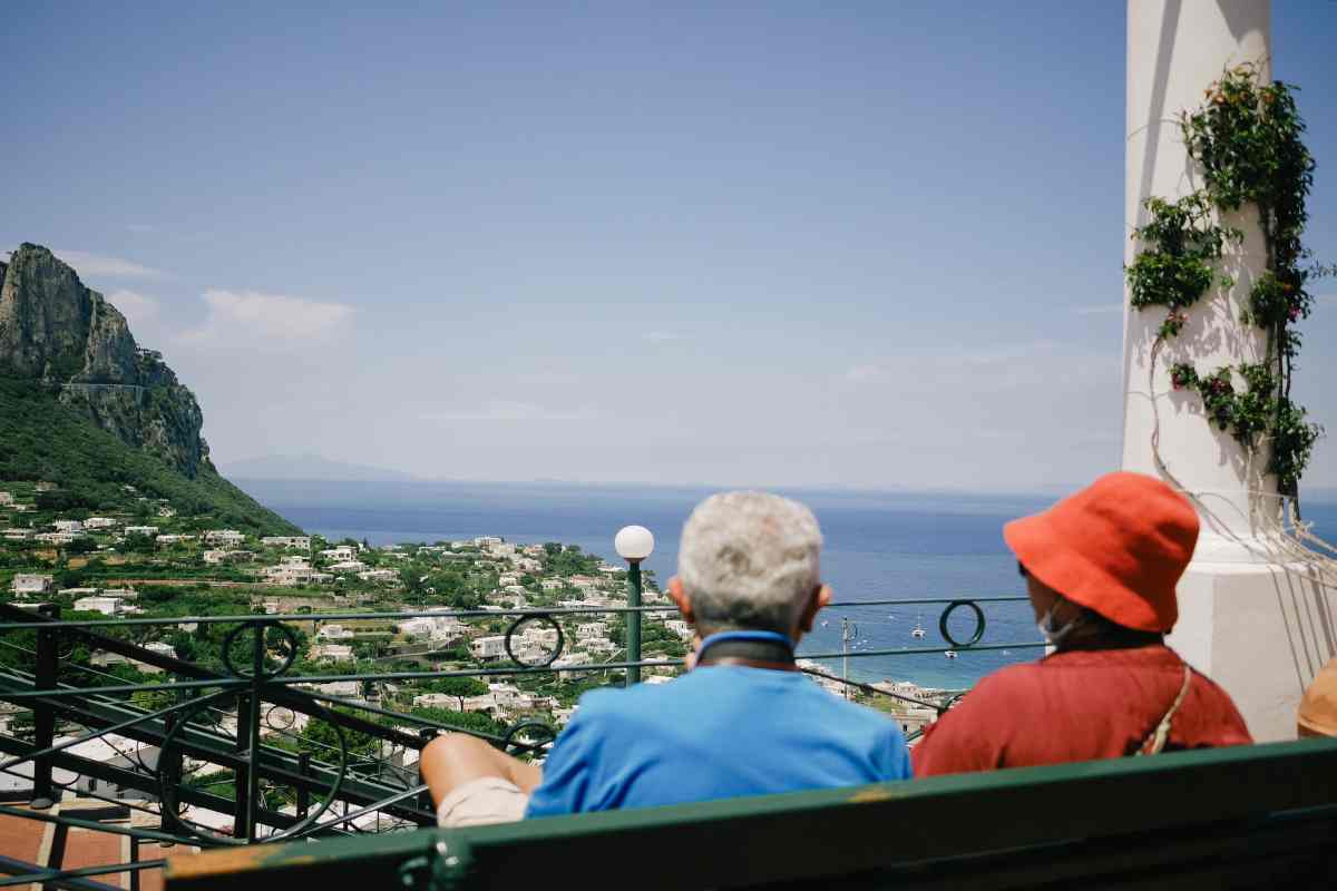 Due anziani su una panchina osservano il mare